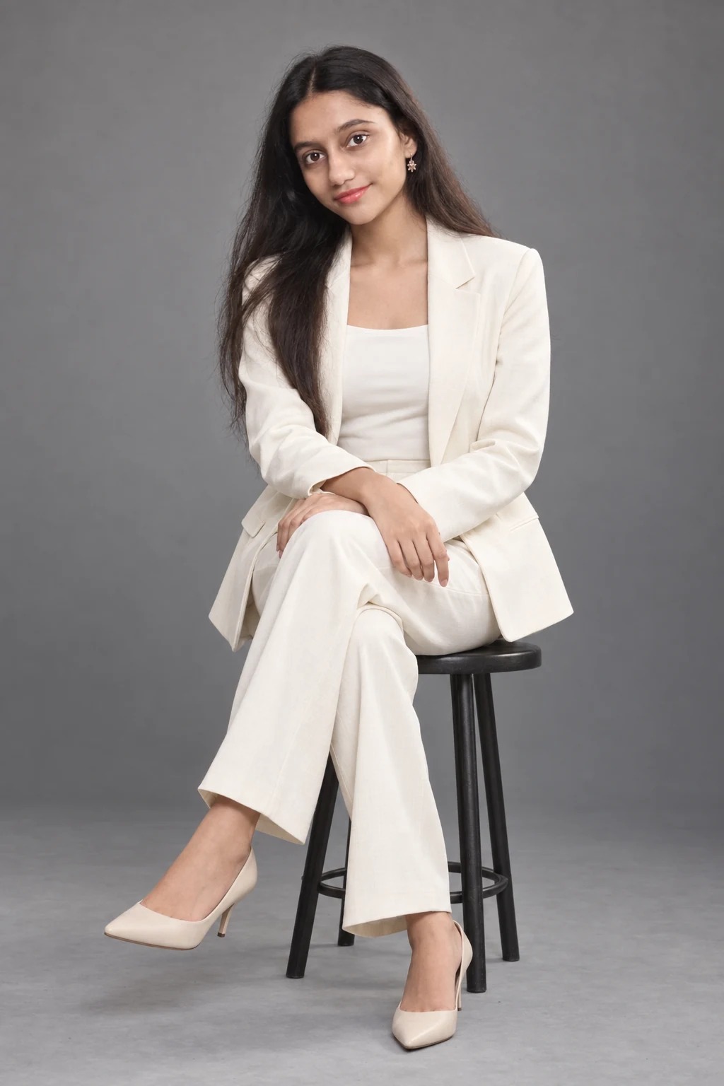 Sreejata in an ivory tailored suit, seated for a studio editorial concept