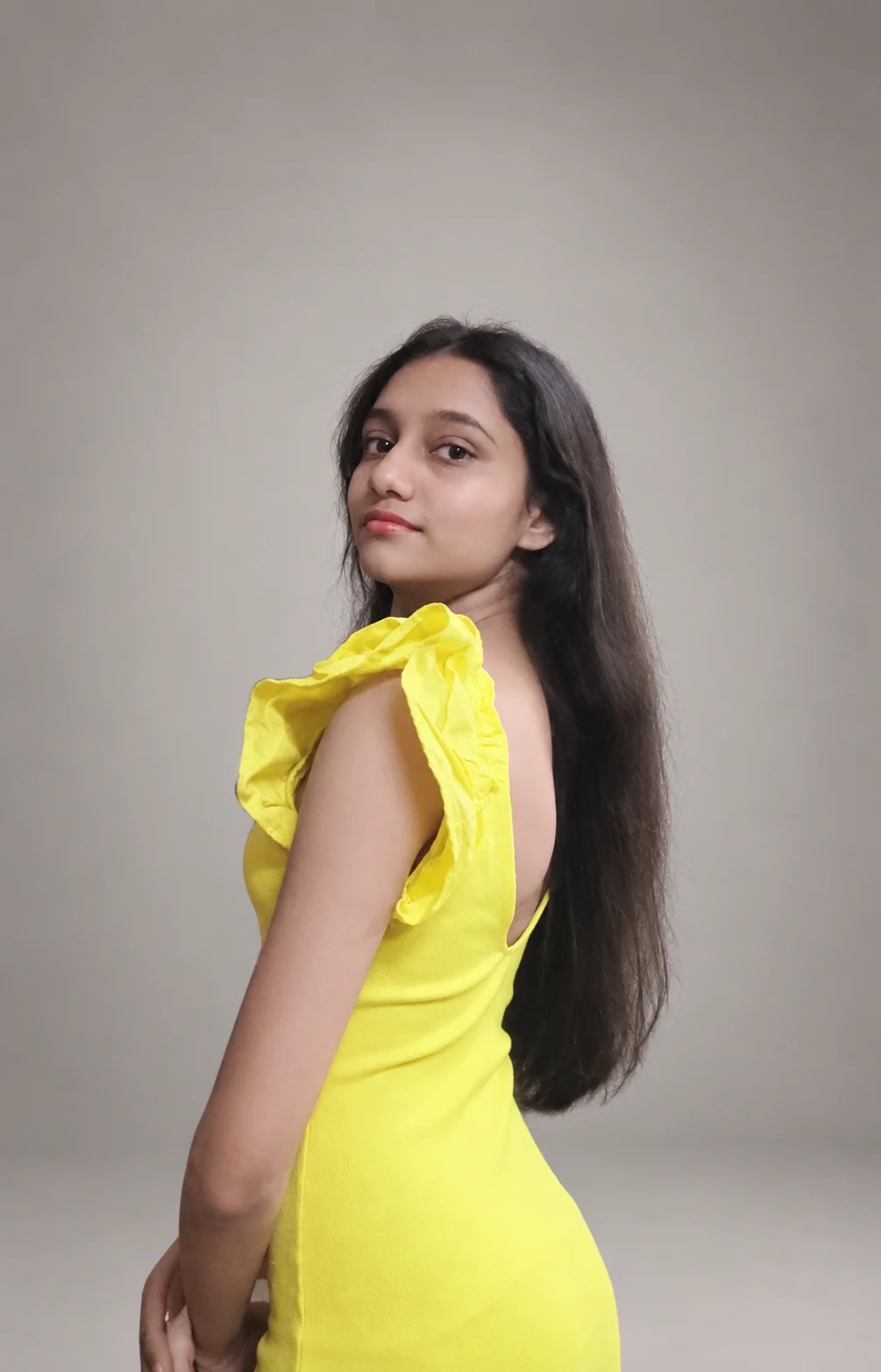 Sreejata looking over her shoulder in her yellow dress