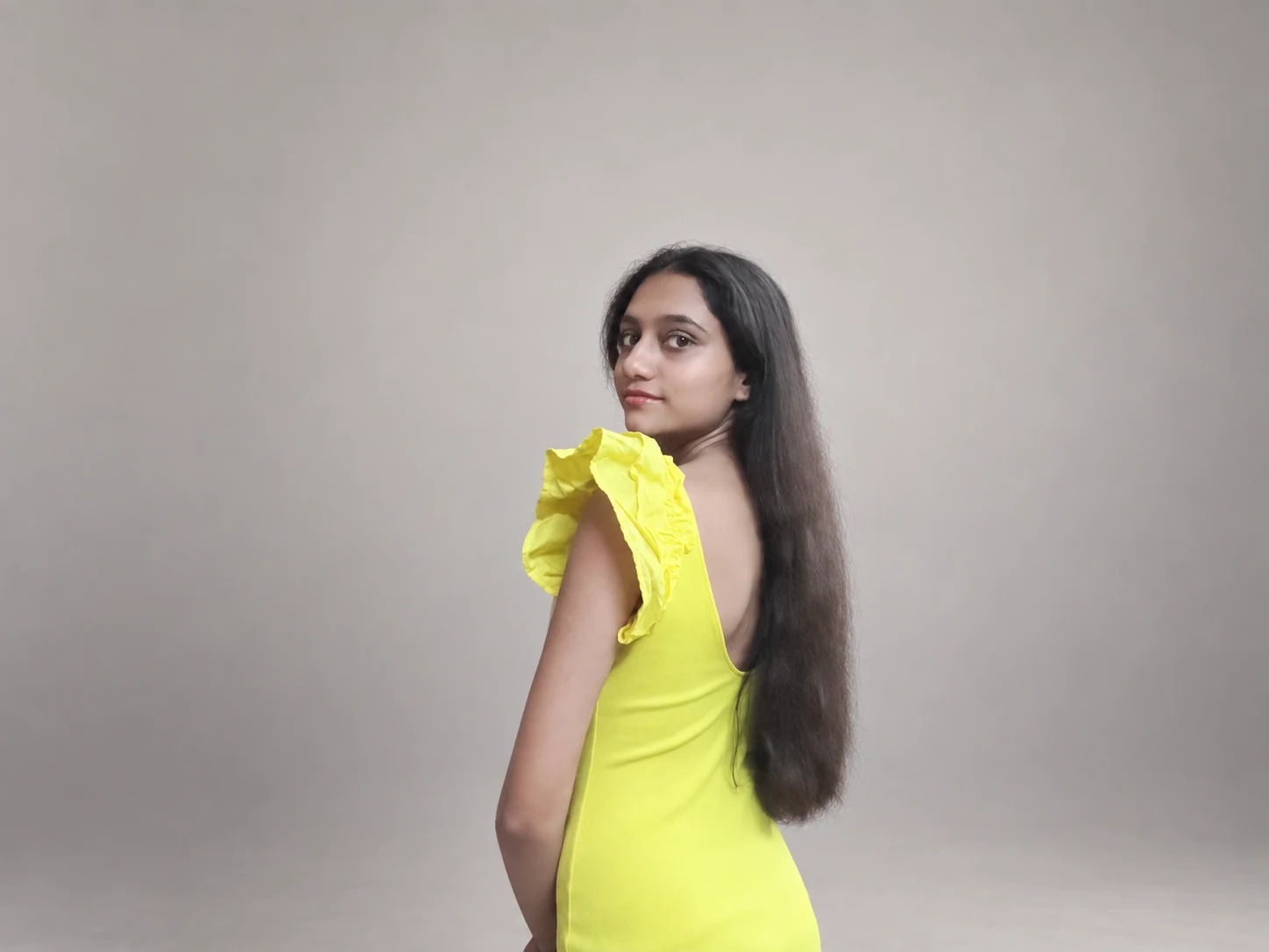 Sreejata in a yellow dress in a studio setting