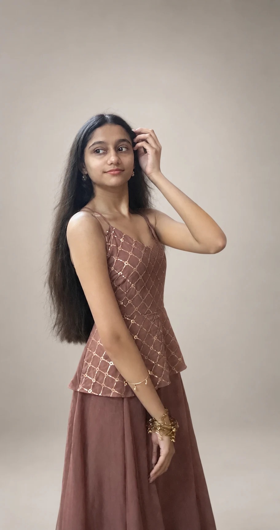 Sreejata in her brown outfit with a hand near her hair