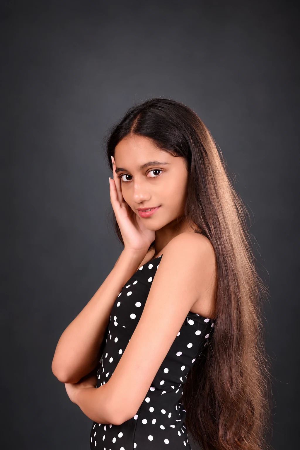 Sreejata in a black polka-dot dress in a charcoal studio